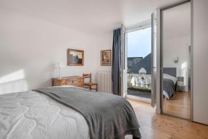 a bedroom with a bed and a sliding glass door at Parenthèse en famille et détente au Pouliguen in Le Pouliguen