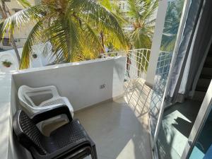 Un balcón con una silla y una palmera en 316 HERMOSO APARTAMENTO EN RODADERo, en Santa Marta