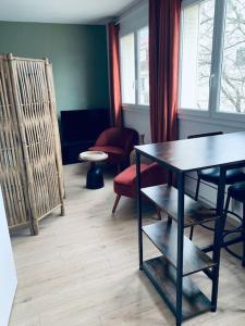 Zimmer mit einem Tisch, Stühlen und Fenstern in der Unterkunft Ile verte entre CHU & vieille ville in Grenoble