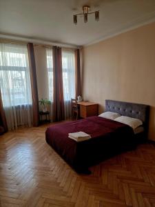 una camera con letto, tavolo e finestre di Kaunas Center Apartment a Kaunas