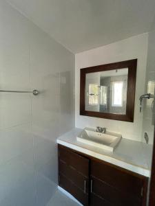 y baño con lavabo, espejo y ducha. en 316 HERMOSO APARTAMENTO EN RODADERo, en Santa Marta