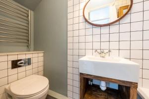 a bathroom with a white toilet and a sink at Lovely self-contained basement studio with kitchen in London
