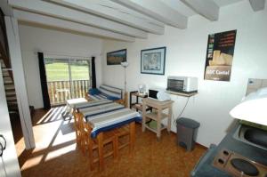 a room with a kitchen with a table and a stove at La Grange du Devezou in Saint-Jacques-des-Blats