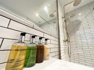 four bottles of alcohol sitting on a shelf in a bathroom at Marske Stables, Yorkshire Dales in Marske