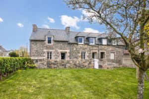an exterior view of a stone house with a yard at Grand jardin et calme au coeur des Côtes-d'Armor in La Bouillie