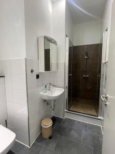 a white bathroom with a sink and a shower at Stadtpension Heilbronn in Heilbronn