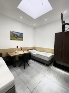 a room with a bed and a desk and a table at Stadtpension Heilbronn in Heilbronn
