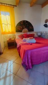 ein Schlafzimmer mit einem Bett mit roten Laken und einem Fenster in der Unterkunft Casetta vista mare 2 Climatizzata in Castellammare del Golfo