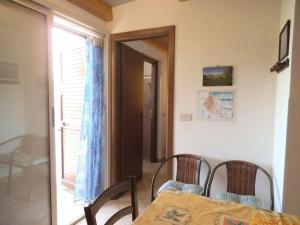 ein Esszimmer mit Tisch und Stühlen und einem Fenster in der Unterkunft Casetta vista mare 2 Climatizzata in Castellammare del Golfo + 6 Fotos