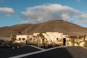 a building with a mountain in the background at Finca Luz in Puerto del Rosario