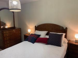 1 dormitorio con cama con almohadas y espejo en Lou Tapata, en Estang