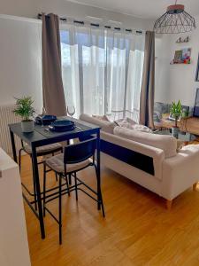um quarto com uma cama, uma mesa e um sofá em Appartement lumineux rénové (proche JO) em Épinay-sur-Seine