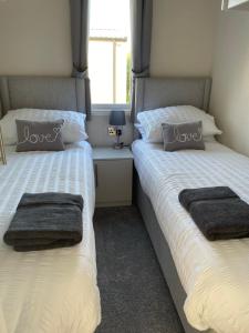 two beds sitting next to each other in a bedroom at 26 Sherwood, South Lakeland Leisure Village in Carnforth