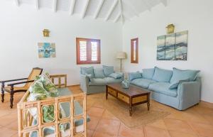 a living room with blue couches and a table at Villa Marie - Habitation Saint Charles in Petit-Bourg