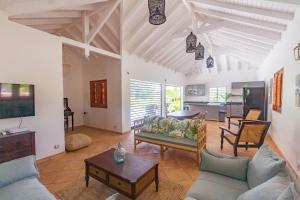 a large living room with couches and a tv at Villa Marie - Habitation Saint Charles in Petit-Bourg