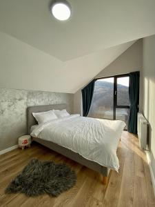 - une chambre avec un lit et une grande fenêtre dans l'établissement Refugiul Panoramic, à Muntele Rece