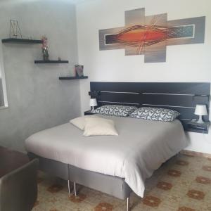 un letto con testiera nera in una stanza di BELVEDERE Appartamento per vacanze a Castel di Iudica