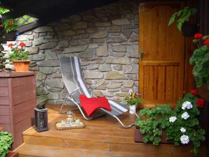 a rocking chair sitting on a porch with a stone wall at Apartment Herlikovice in Trutnov