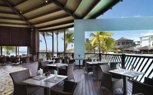 a restaurant with tables and chairs and the ocean at The Ohana Studio in Saint-François