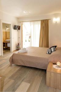 a bedroom with a large bed and a large window at MOLAROTTO CAMERE CON ANGOLO COTTURA in San Teodoro