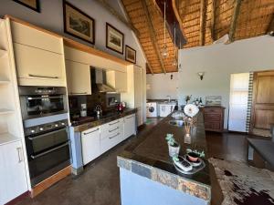 a large kitchen with white cabinets and appliances at Mpofu Lodge in Bergview