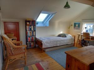 a bedroom with a bed and a book shelf at Ljust boende, egen ingång och trädgård i centrum in Varberg