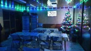 a christmas tree in a room with tables and chairs at Pensiunea Maria in Cerna