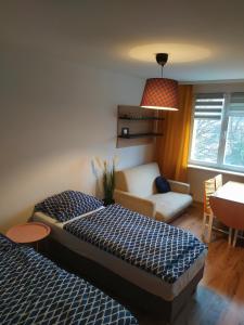 una camera d'albergo con due letti e un divano di Good Morning Podzamcze a Wałbrzych