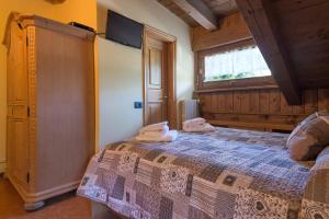een slaapkamer met een bed met twee handdoeken erop bij Al Mughetto in Auronzo di Cadore