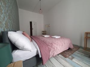 una camera da letto con un letto con una coperta rosa e cuscini di WE STAY APARTMENTS a Bratislava