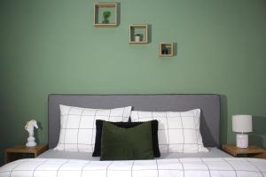 a bedroom with a white bed with a green wall at Center Of Elegance in Xanthi