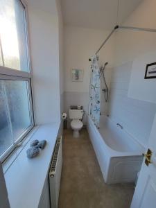 a white bathroom with a tub and a toilet at the devon and cornwall inn in Millbrook
