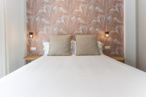 a white bed with two pillows in a bedroom at Apartamentos 7 dreams in Málaga