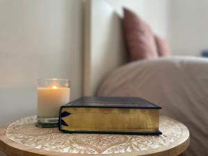 een kaars en een boek op een tafel naast een bed bij Appartement 4 personnes JO Paris 2024 in Vincennes
