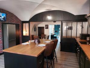 uma sala de jantar com uma mesa com cadeiras e uma cozinha em L'INATTENDU Vue imprenable, lits préparés et ménage inclus em Montaigu