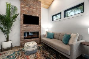 uma sala de estar com um sofá e uma lareira em Petit Paradis Studio with hot tub em Fredericksburg