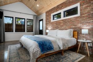um quarto com uma parede de tijolos e uma cama em Petit Paradis Studio with hot tub em Fredericksburg