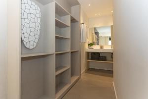 a walk in closet with white shelves and a mirror at Apartamentos 7 dreams in Málaga
