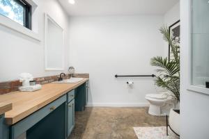 uma casa de banho com um lavatório e um WC em Petit Paradis Studio with hot tub em Fredericksburg