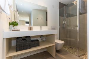 uma casa de banho com um lavatório, um chuveiro e um WC. em Apartamentos 7 dreams em Málaga