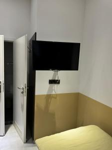 a flat screen tv on the wall of a bedroom at Stadtpension Heilbronn in Heilbronn