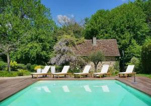 a pool with chaise lounge chairs and a group at Le Rustique in Sarlande