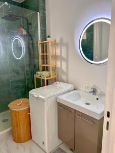 a bathroom with a sink and a toilet and a mirror at Appartement lumineux rénové (proche JO) in Épinay-sur-Seine