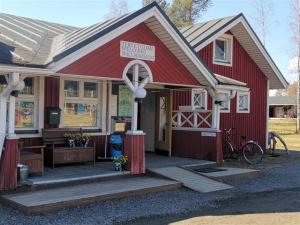 a red building with a sign on the front of it at Emolahti Camping in Pyhäjärvi