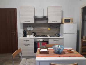 a kitchen with a table and a stove and refrigerator at RiDi Home Zona Ospedaliera in Naples