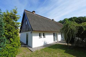 ein weißes Haus mit schwarzem Dach in der Unterkunft Fischerhaus Usedom in Kamminke