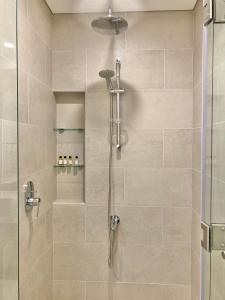 a bathroom with a shower with a glass door at White Sage - Tranquil Haven 1BR With Burj Views in Dubai