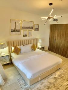 a bedroom with a large white bed and a ceiling fan at White Sage - Tranquil Haven 1BR With Burj Views in Dubai