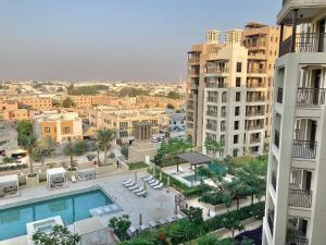 a view of a city with a pool and buildings at White Sage - Tranquil Haven 1BR With Burj Views in Dubai