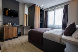 ArnavutköyにあるFLY POINT AIRPORT HOTELのベッドとテレビが備わるホテルルームです。